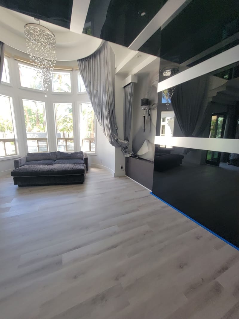 Modern living room with dark accent wall and glossy black ceiling