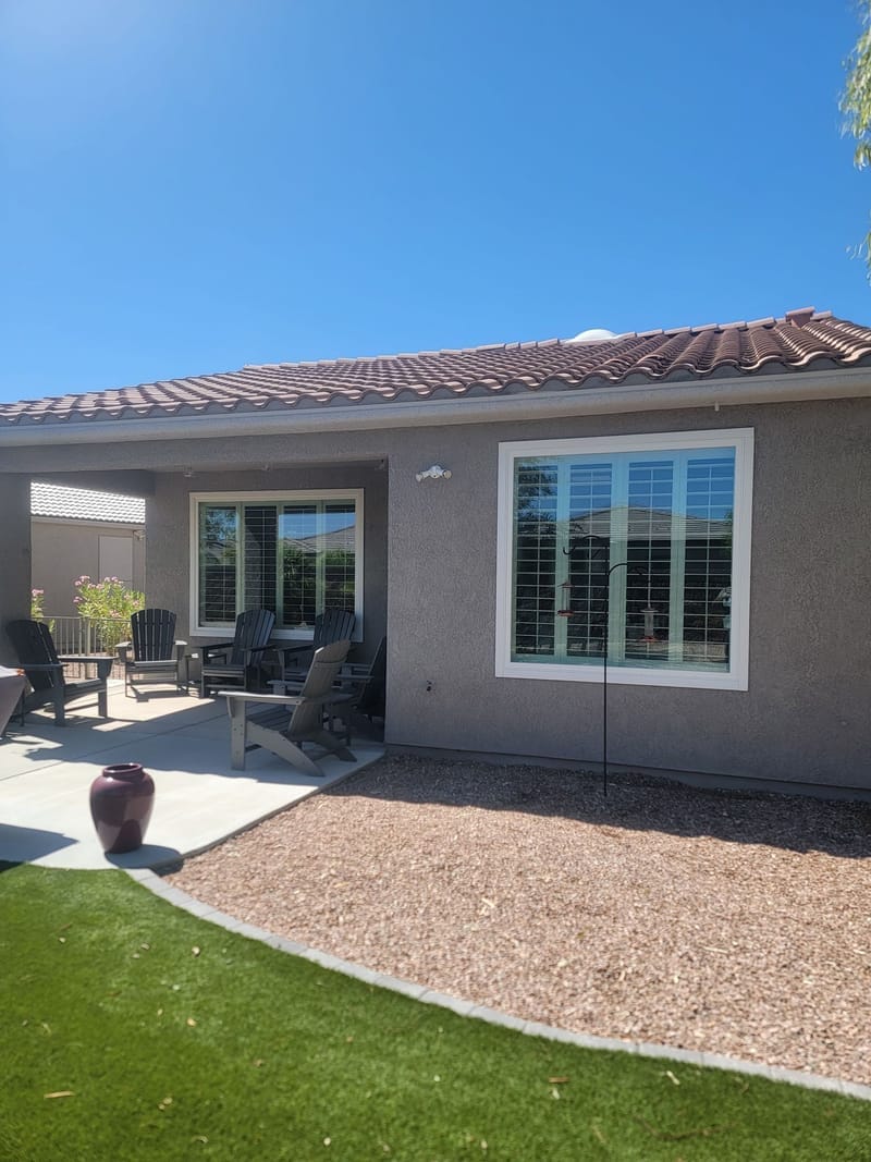Home exterior backyard view with painted stucco and covered patio