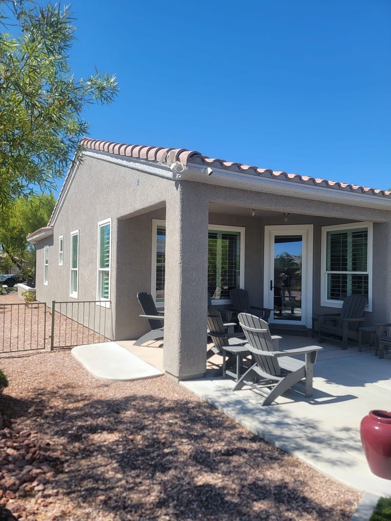 Home exterior side view with painted stucco and porch columns