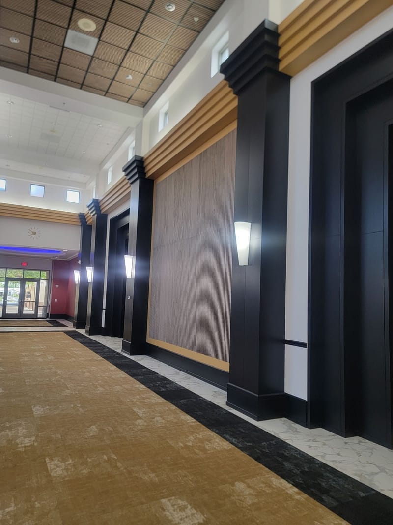 Commercial corridor with painted black columns and wood accent panels
